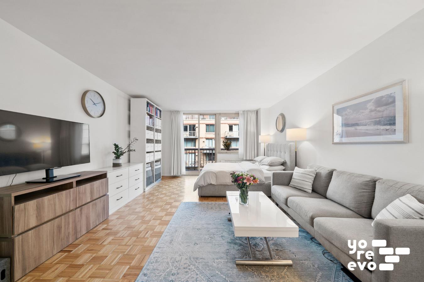 393 West 49th Street, Unit 4DD Manhattan, NY 10019 - Photo 1 of 9 a living room with furniture and a flat screen tv