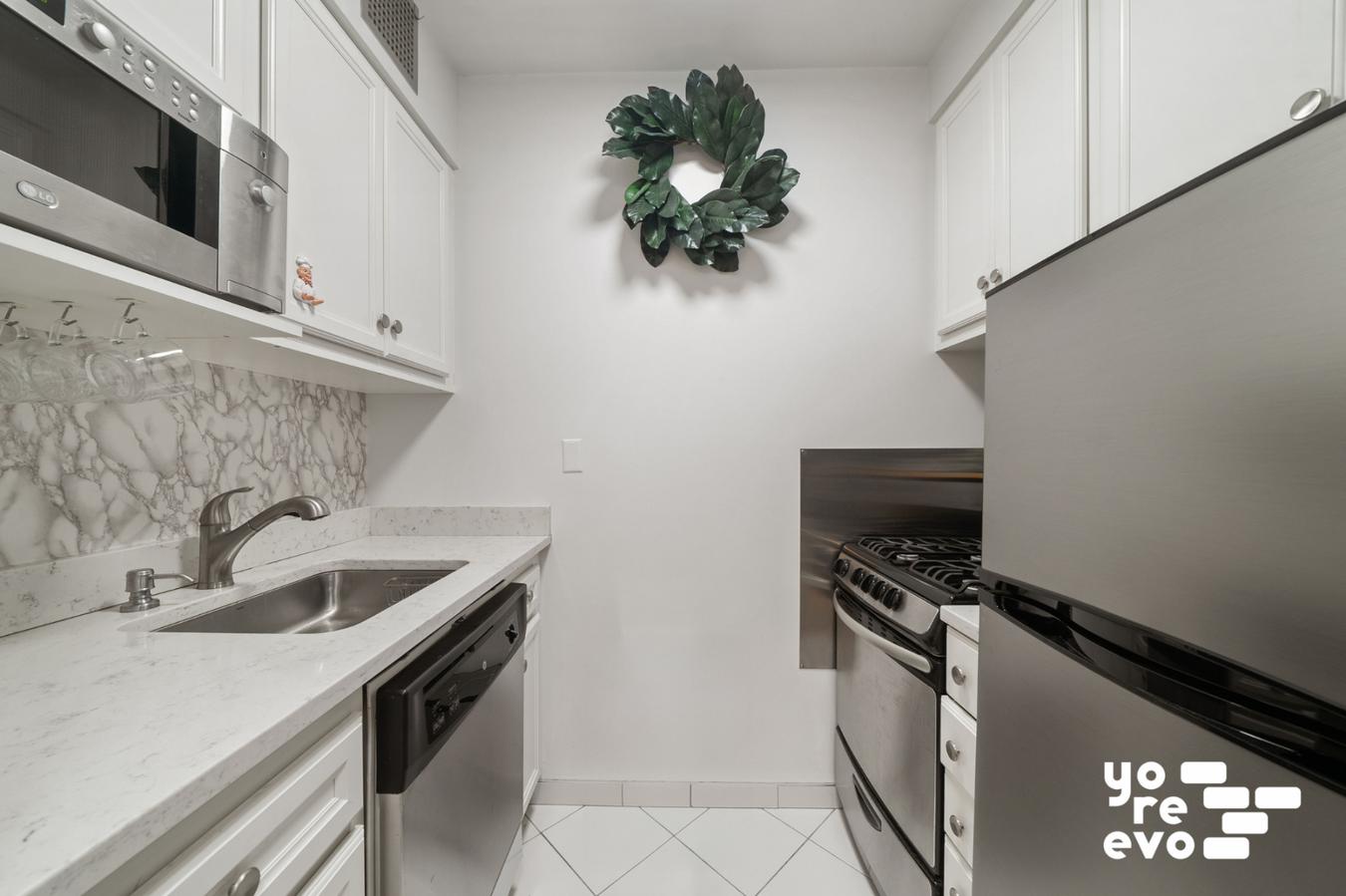 393 West 49th Street, Unit 4DD Manhattan, NY 10019 - Photo 3 of 9 a kitchen with a sink and a stove top oven