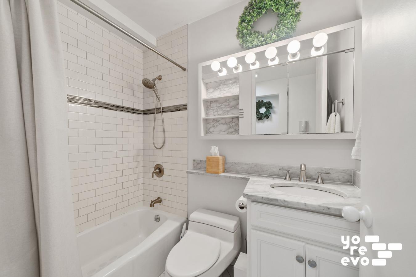 393 West 49th Street, Unit 4DD Manhattan, NY 10019 - Photo 6 of 9 a bathroom with a granite countertop sink toilet and shower