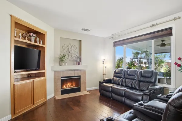 a living room with furniture a flat screen tv and a fireplace