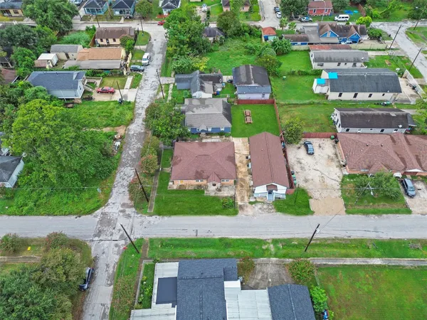 an aerial view of residential houses with outdoor space and trees