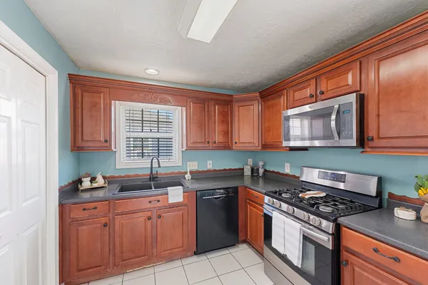 a kitchen with stainless steel appliances granite countertop a stove a sink and a microwave