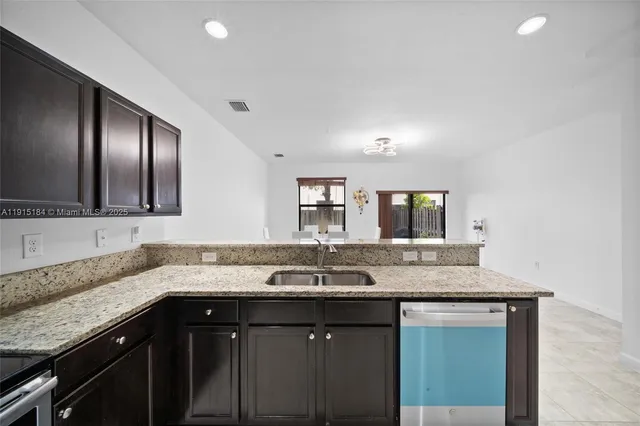 a sink with granite countertop cabinets and granite counter tops