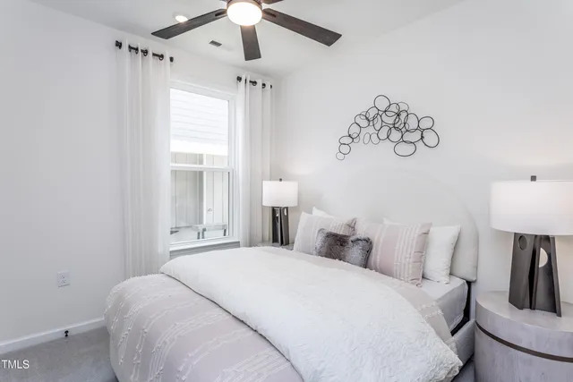 a bedroom with a bed and a lamp on the dresser