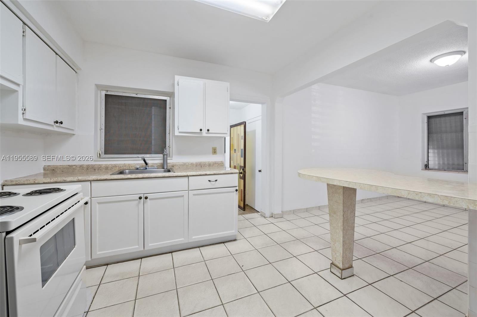 42 East 16th Street Hialeah, FL 33010 - Photo 12 of 30 a kitchen with cabinets and white appliances