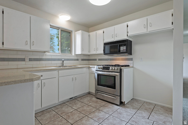 1722 Kimsbrough Road Sandy, UT 84092 - Photo 11 of 29 Kitchen featuring white cabinetry, light-toned countertops, a stainless steel gas range, and an over-the-range microwave
