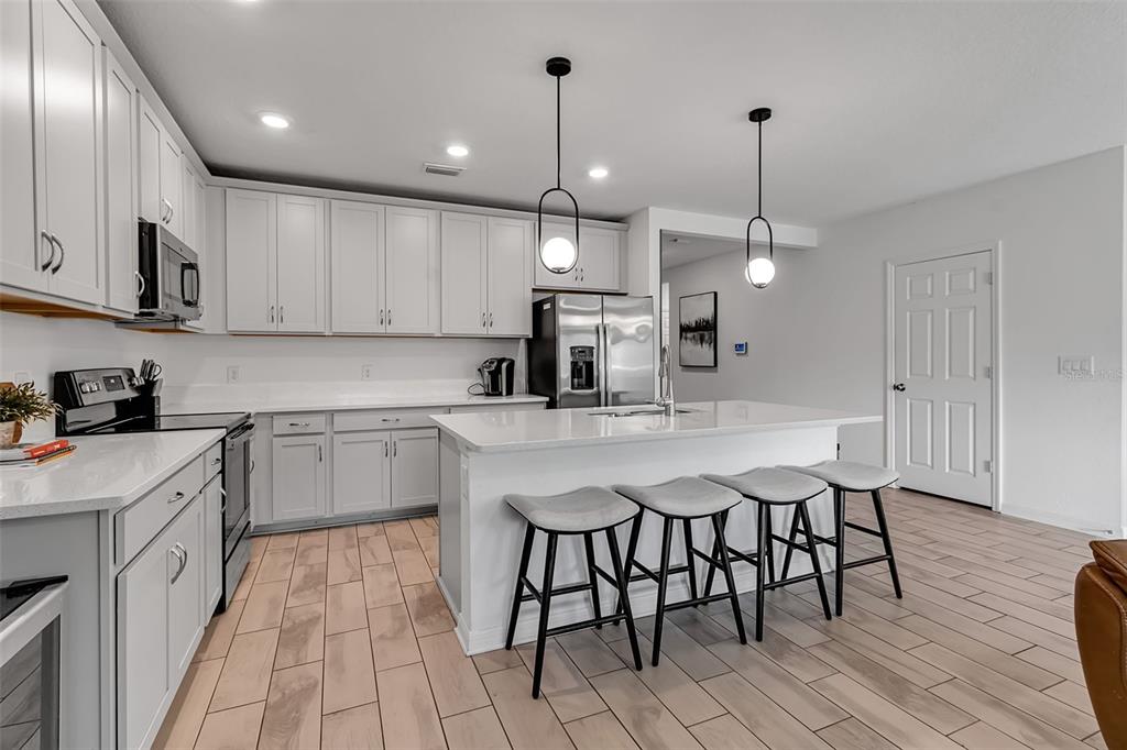 5434 Patano Loop Palmetto, FL 34221 - Photo 12 of 93 a kitchen with stainless steel appliances granite countertop a sink a stove a refrigerator and island with wooden floor