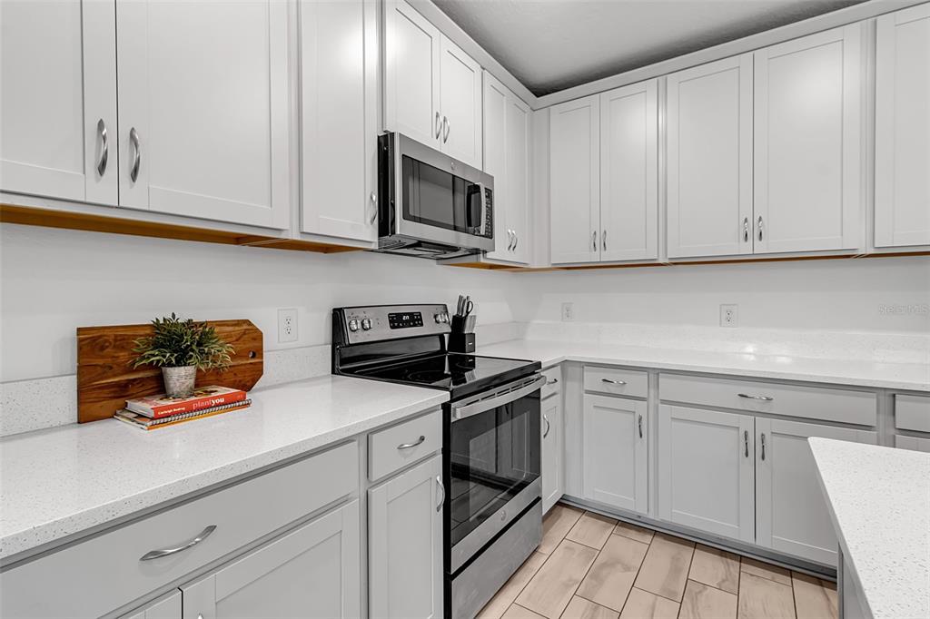 5434 Patano Loop Palmetto, FL 34221 - Photo 15 of 93 a kitchen with stainless steel appliances granite countertop white cabinets sink and a microwave