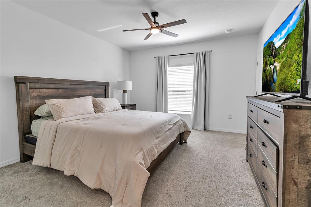 5434 Patano Loop Palmetto, FL 34221 - Photo 28 of 93 a bedroom with a bed and a chandelier