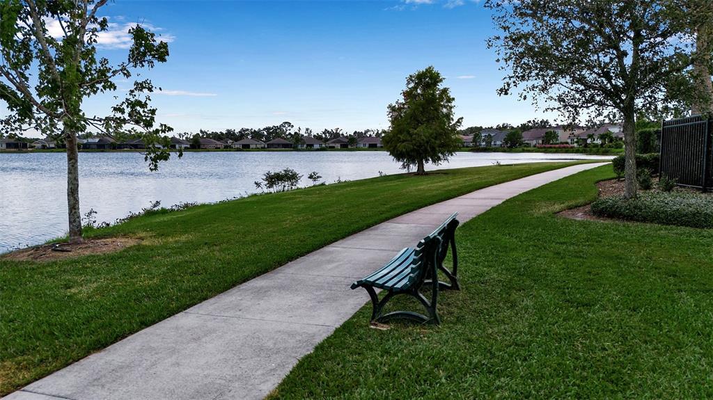 5434 Patano Loop Palmetto, FL 34221 - Photo 60 of 93 a park bench sitting in the grass near a lake