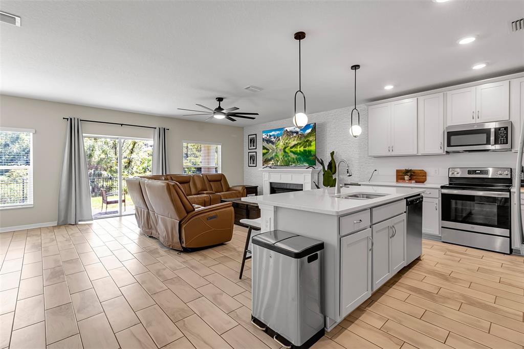 5434 Patano Loop Palmetto, FL 34221 - Photo 9 of 93 a kitchen with stainless steel appliances kitchen island granite countertop a stove a sink and a granite counter tops
