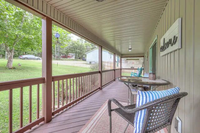 a view of a patio with table and chairs with wooden floor and fence