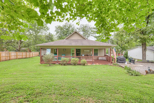 a view of a house with backyard and a tree