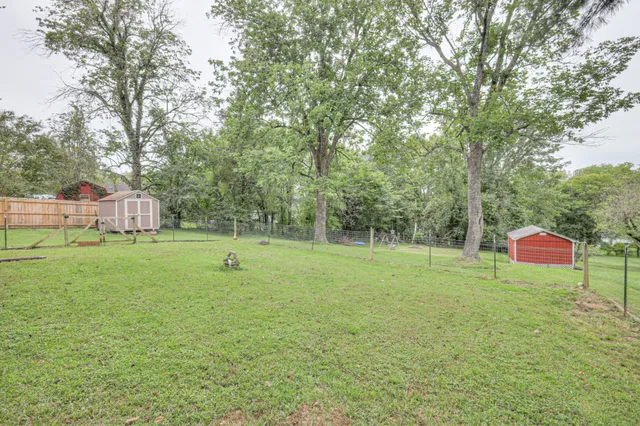 a front view of a house with a yard and trees
