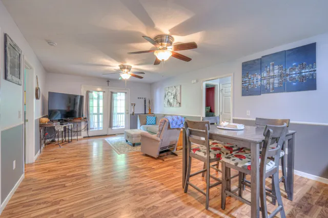 a living room with furniture a chandelier and a flat screen tv