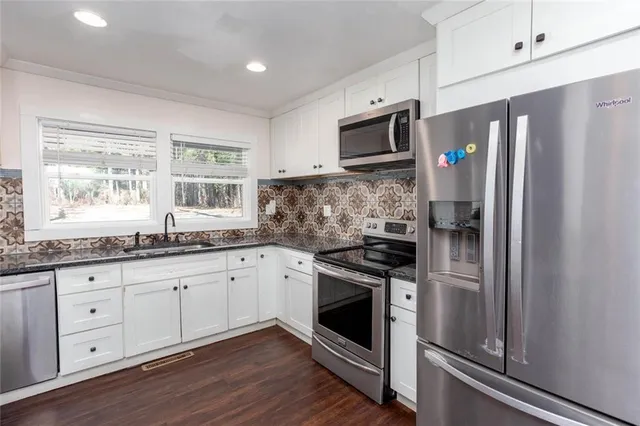a kitchen with stove a sink and a wooden floor