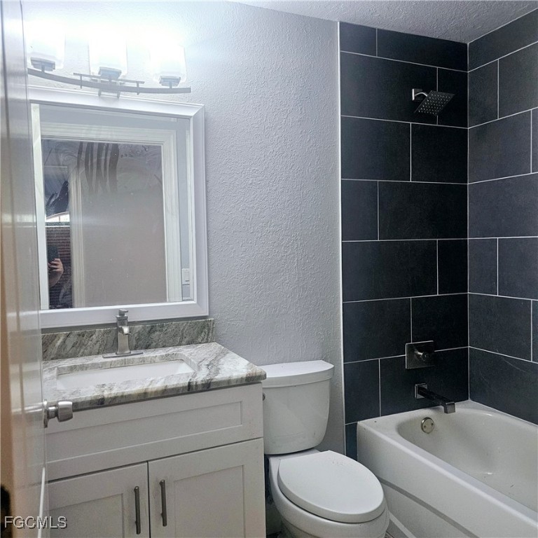 3780 Randall Boulevard Naples, FL 34120 - Photo 9 of 12 a bathroom with a granite countertop toilet a sink and a mirror