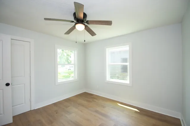 a view of an empty room and window ceiling fan