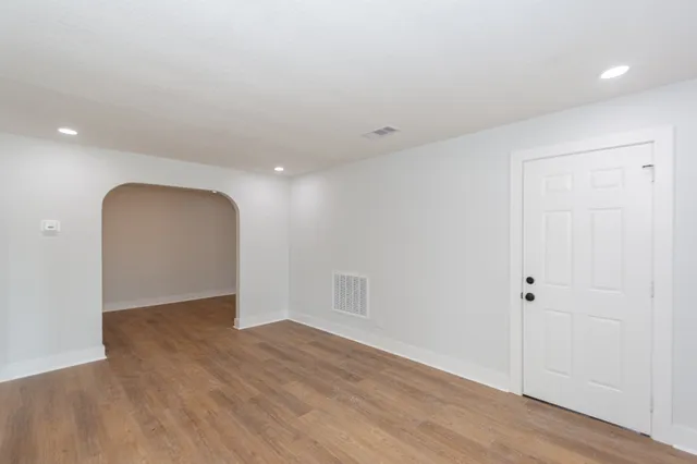 a view of an empty room with wooden floor