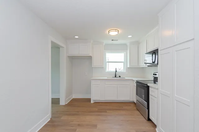 a kitchen with a sink a window and stainless steel appliances