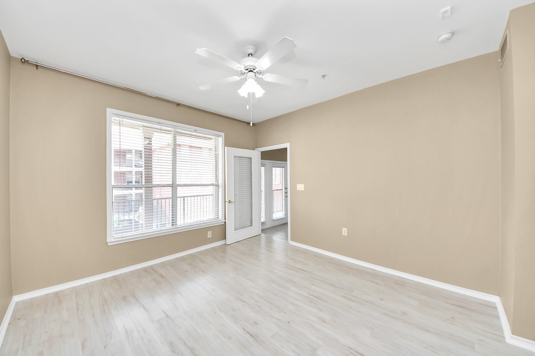 2400 McCue Road, Unit 333 Houston, TX 77056 - Photo 17 of 50 an empty room with wooden floor chandelier fan and windows