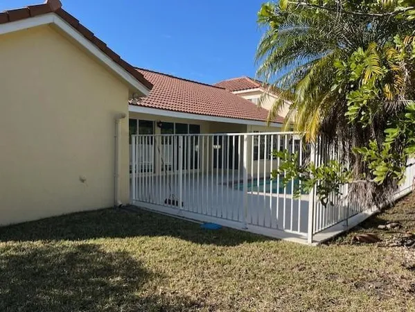 a view of a house with a small yard and wooden fence