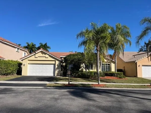 a front view of a house with a garden and yard
