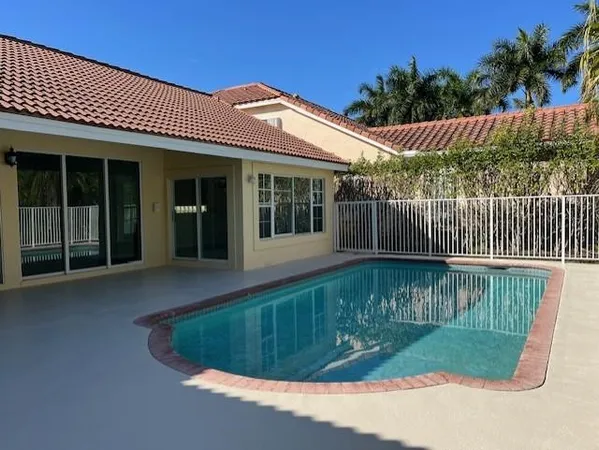 a view of a house with swimming pool and wooden fence