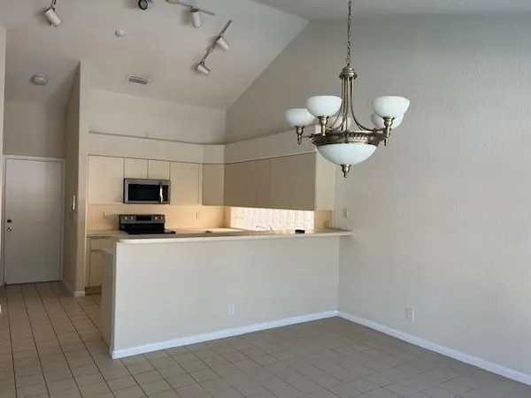 a view of a kitchen with a sink and refrigerator