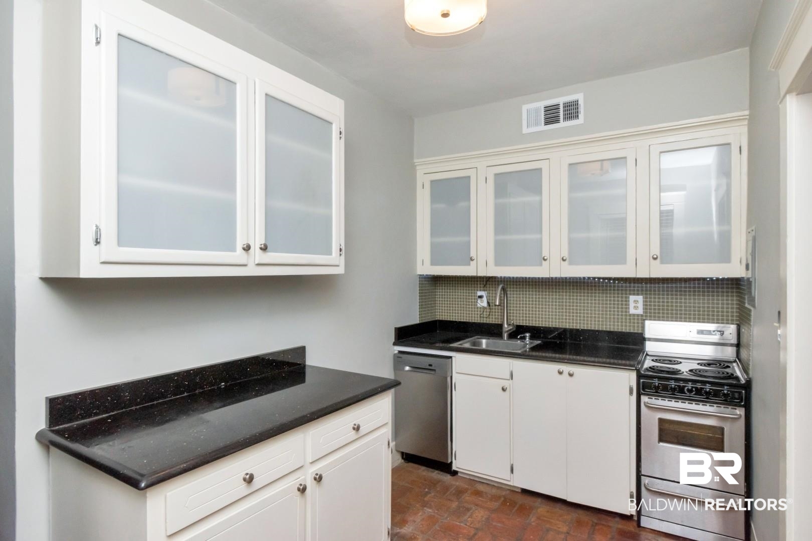 1602 Government Street, Unit 1A Mobile, AL 36604 - Photo 9 of 24 Kitchen with appliances with stainless steel finishes, white cabinets, and brick flooring