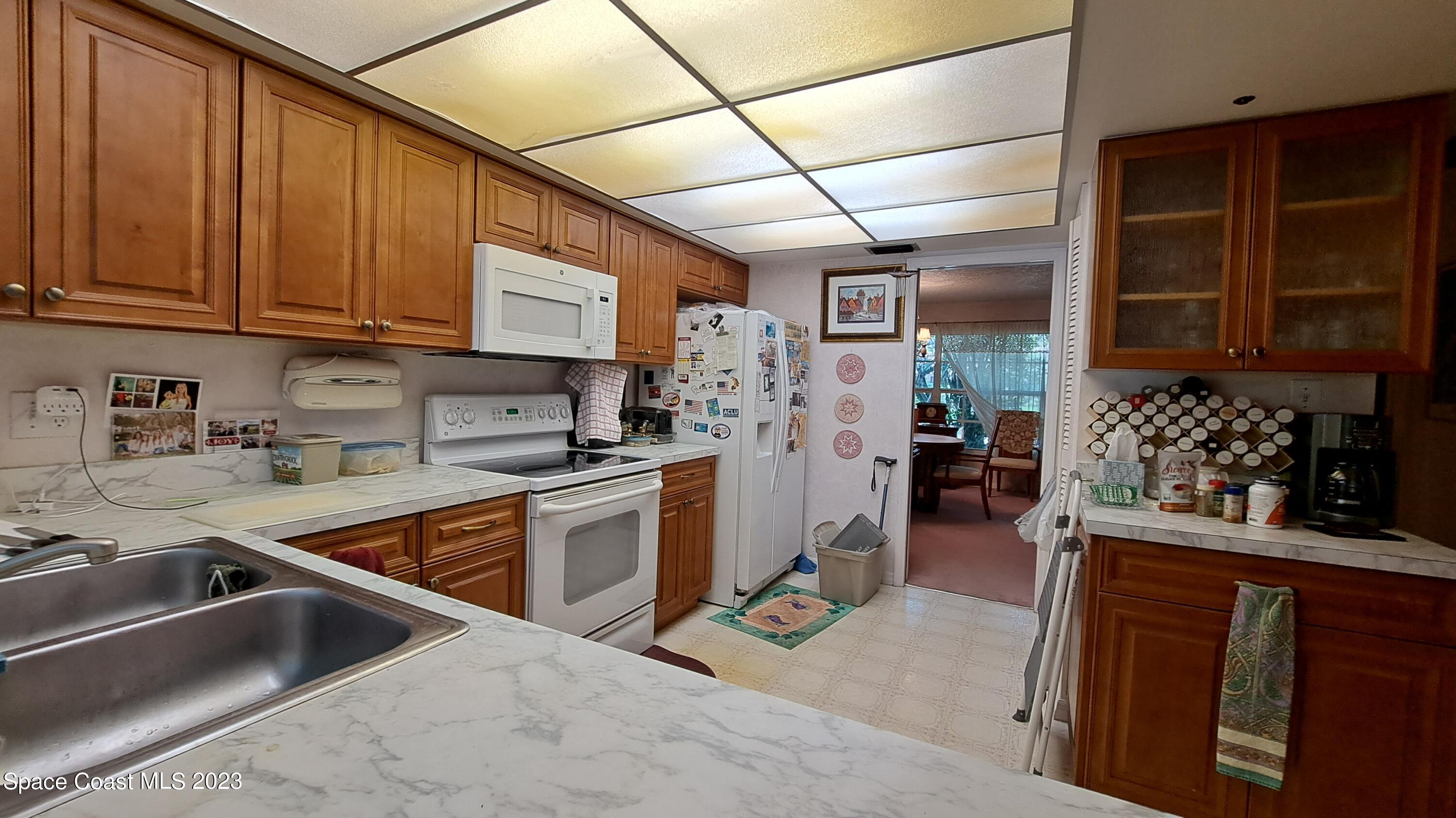 1083 Pineapple Avenue Northeast Palm Bay, FL 32905 - Photo 17 of 26 a kitchen with stainless steel appliances granite countertop a sink stove and refrigerator