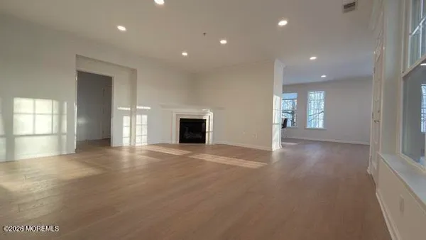 an empty room with windows and fireplace