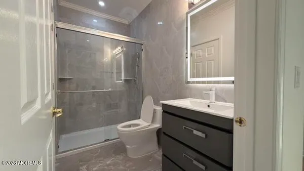 a bathroom with a sink a toilet and shower