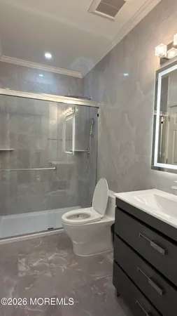 a bathroom with a sink mirror and shower