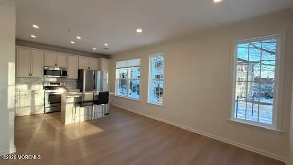 a kitchen with stainless steel appliances kitchen island granite countertop a refrigerator and microwave