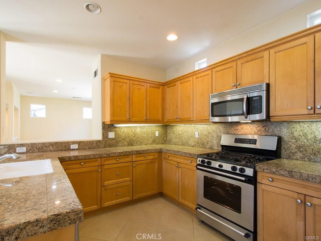 7 Silvermaple Irvine, CA 92618 - Photo 3 of 21 a kitchen with stainless steel appliances granite countertop a stove a sink and a microwave