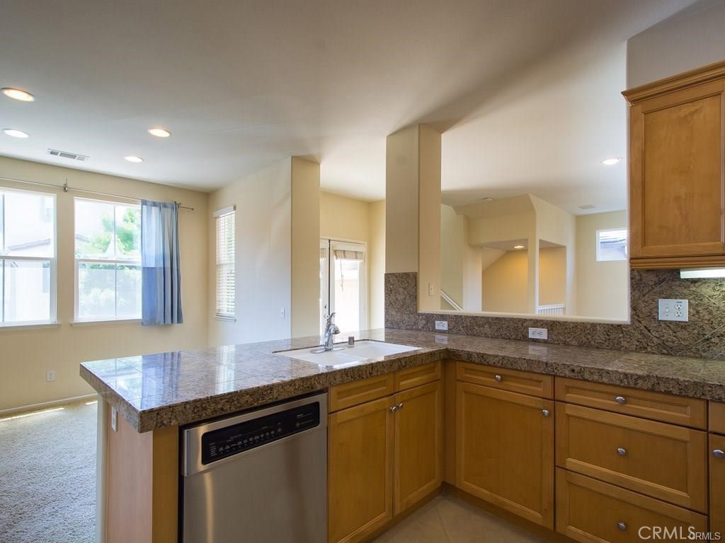 7 Silvermaple Irvine, CA 92618 - Photo 4 of 21 a kitchen with granite countertop a sink and white cabinets