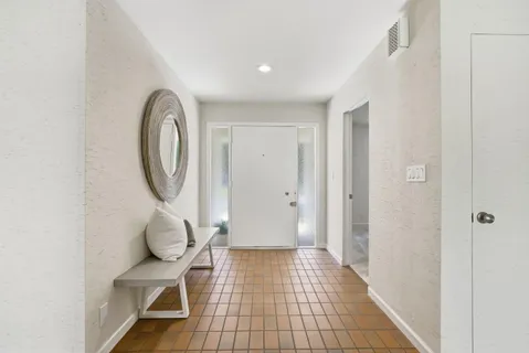 a bedroom with a bed and a dresser next to a window