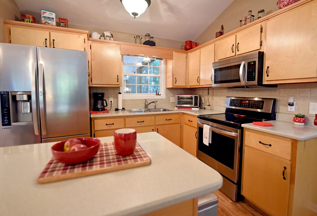 31 Lance Crossing Road Blairsville, GA 30512 - Photo 38 of 52 a kitchen with stainless steel appliances granite countertop a refrigerator a stove top oven a sink dishwasher and white cabinets