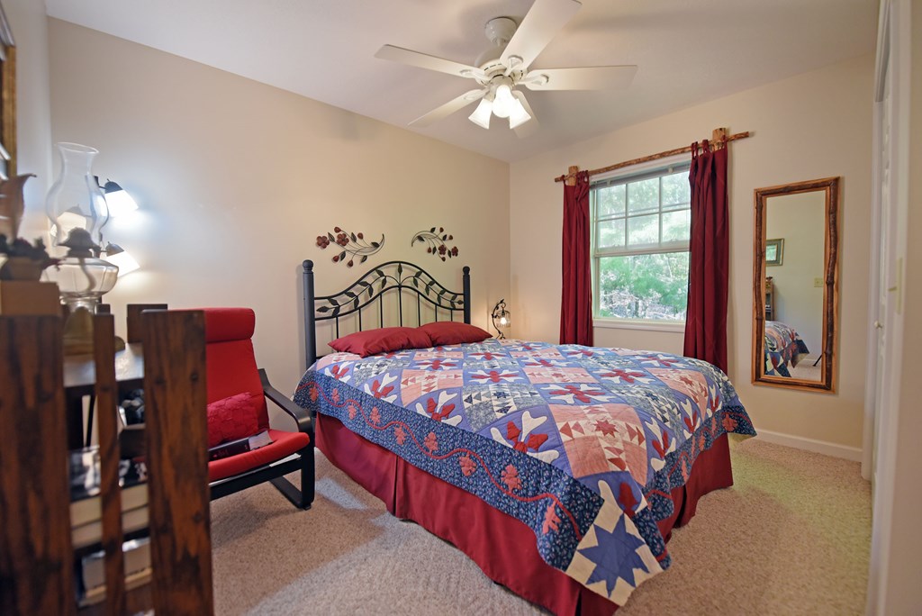 31 Lance Crossing Road Blairsville, GA 30512 - Photo 44 of 52 a bedroom with a bed and a chandelier