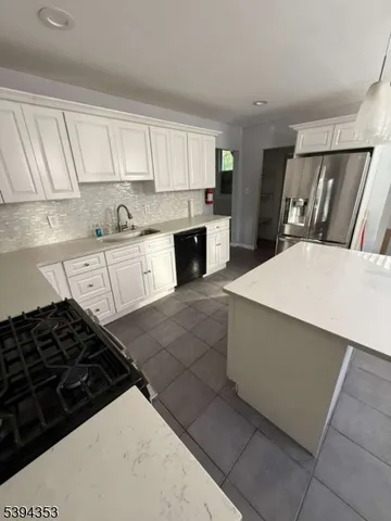 a kitchen with granite countertop a stove sink and cabinets