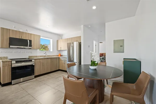 a kitchen with a table chairs microwave and refrigerator