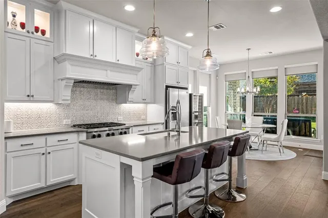 a kitchen with sink stove and cabinets