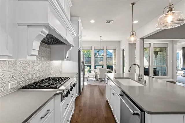 a kitchen that has a lot of cabinets in it and wooden floors