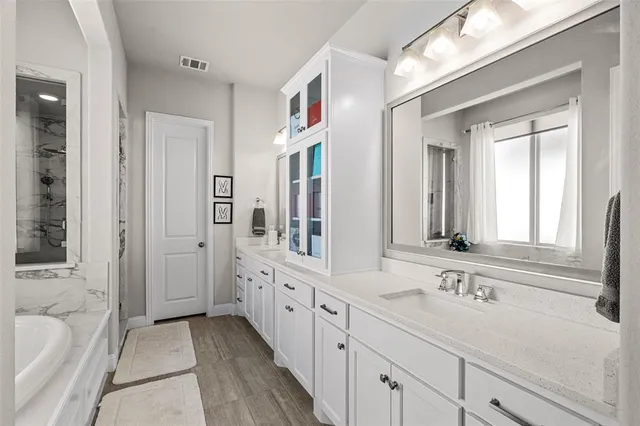 a bathroom with a tub sink and mirror
