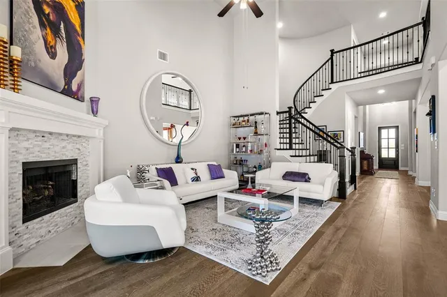 a kitchen with kitchen island granite countertop a sink a stove a refrigerator and white cabinets with wooden floor