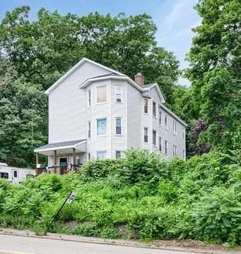 1442 Main Street, Unit 2 Worcester, MA 01603 - Photo 3 of 14 a view of a white house with large windows and plants