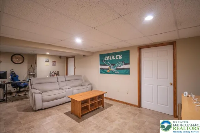 a living room with furniture a flat screen tv and gym equipment