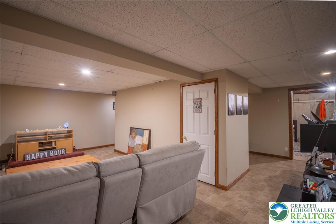 3955 Coplay Creek Road Schnecksville, PA 18078 - Photo 30 of 34 a living room with furniture a flat screen tv and gym equipment