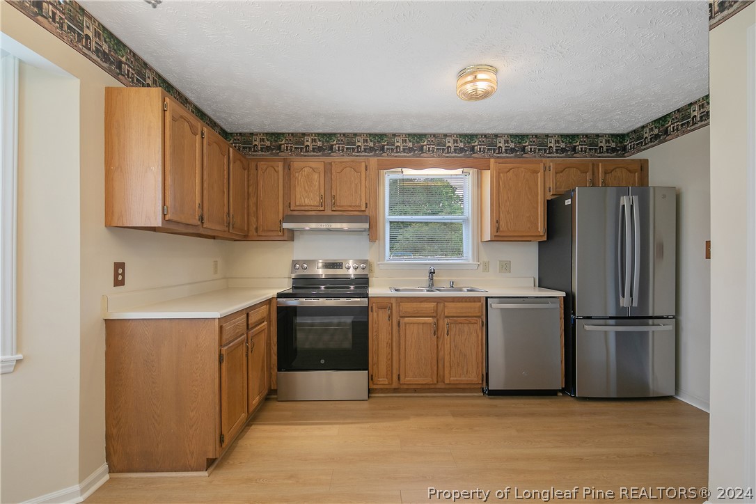 51 Overlook Road Cameron, NC 28326 - Photo 16 of 40 a kitchen with stainless steel appliances granite countertop a refrigerator a sink and a stove